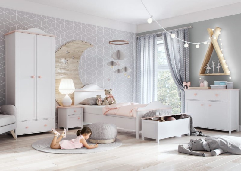 Pokój dziewczynki z białymi meblami, dużą dekoracją księżyca i dzieckiem na dywanie.