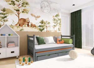 Szare drewniane łóżko dziecięce z wysuwanym spaniem i szufladami, w aranżacji pokoju z leśną tapetą.