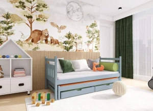 Niebieskie łóżko dziecięce drewniane wysuwane z szufladami, w aranżacji pokoju z leśną tapetą.