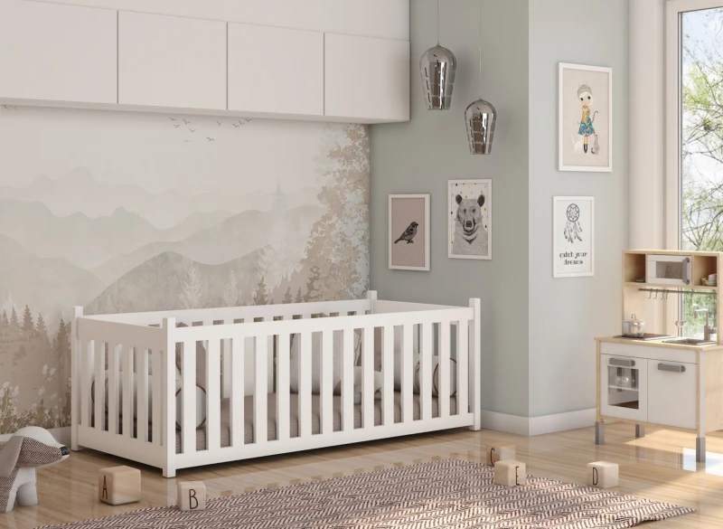 Klasyczne białe łóżeczko szczebelkowe dla niemowlaka w stylu skandynawskim.