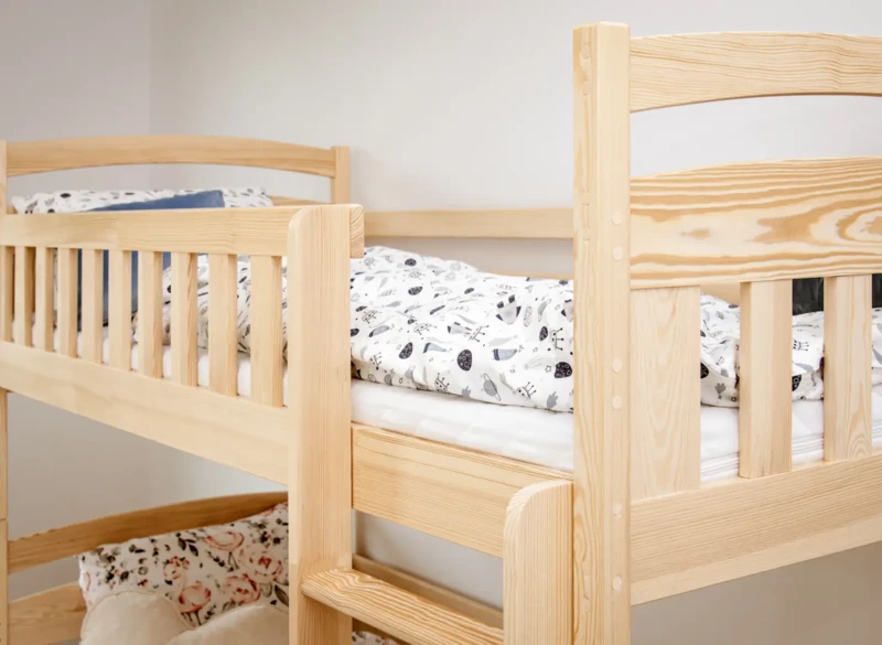 Zagłówek i barierka górnego spania w stabilnym łóżku piętrowym.