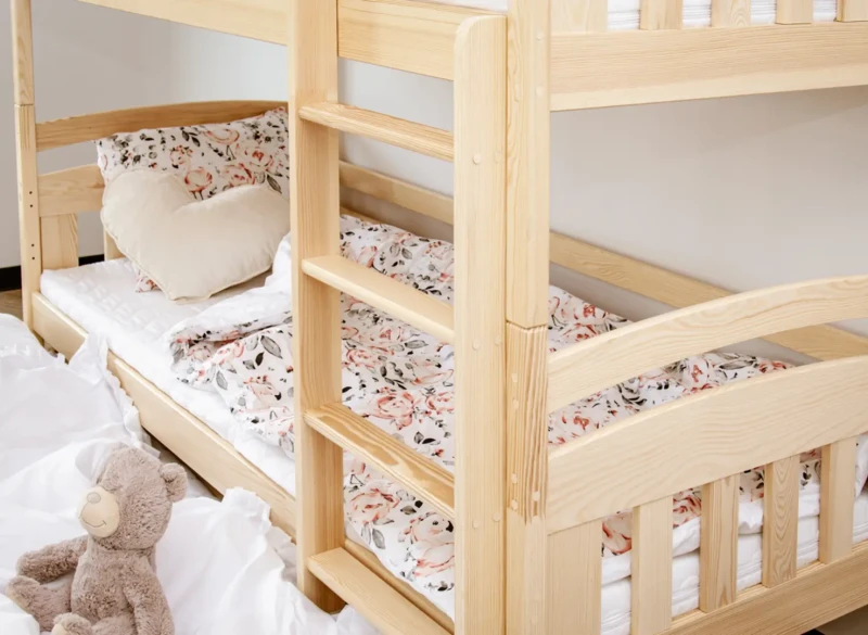 Solidna drabinka i barierki zabezpieczające w sosnowym łóżku piętrowym dla dzieci.