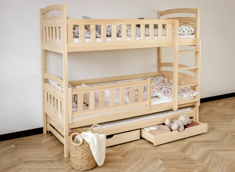 Trzyosobowe łóżko piętrowe z drewna sosnowego z wysuwanym spaniem i barierkami ochronnymi.