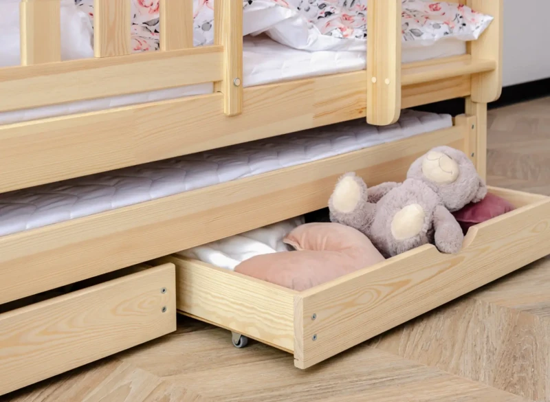 Praktyczne szuflady pod łóżkiem piętrowym na pościel i zabawki w pokoju dziecka.