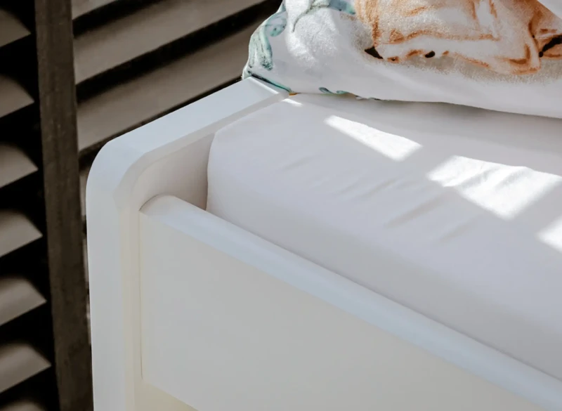 Detal rogu białego łóżka dziecięcego z materacem