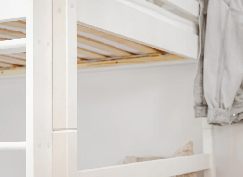 Solidna konstrukcja i barierki białego łóżka drewnianego dla dzieci.