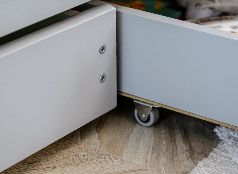 Kółka jezdne szuflady pod łóżkiem ułatwiające dostęp do rzeczy.