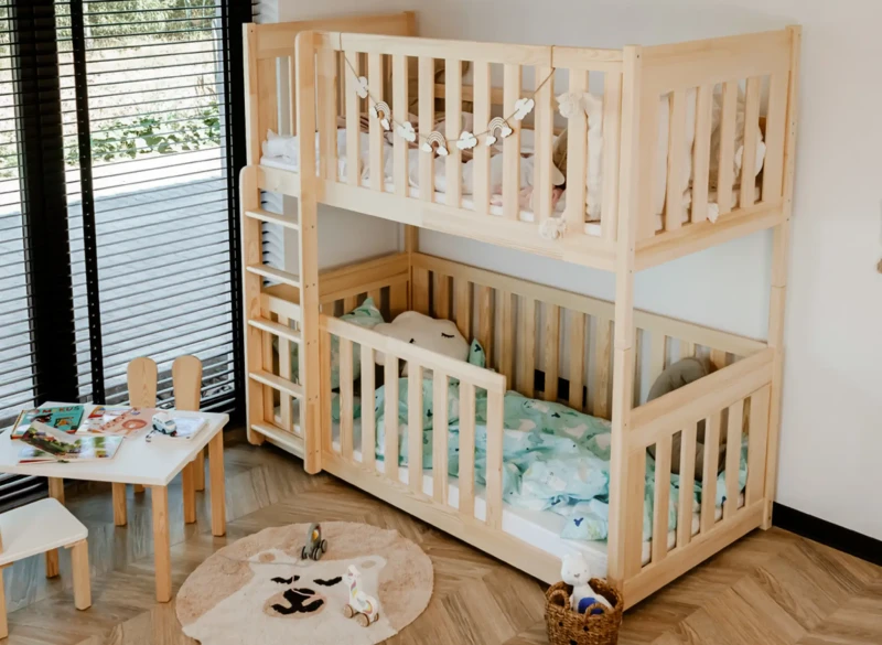 Dwupoziomowe drewniane łóżko piętrowe z barierkami ochronnymi i drabinką do pokoju dziecięcego.