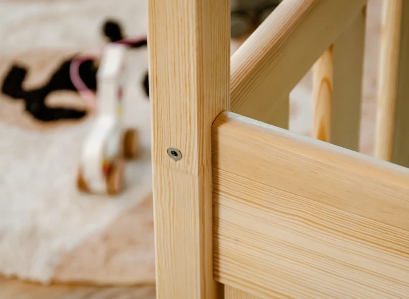 Precyzyjne wykończenie i montaż elementów konstrukcyjnych sosnowego łóżka dla dzieci.