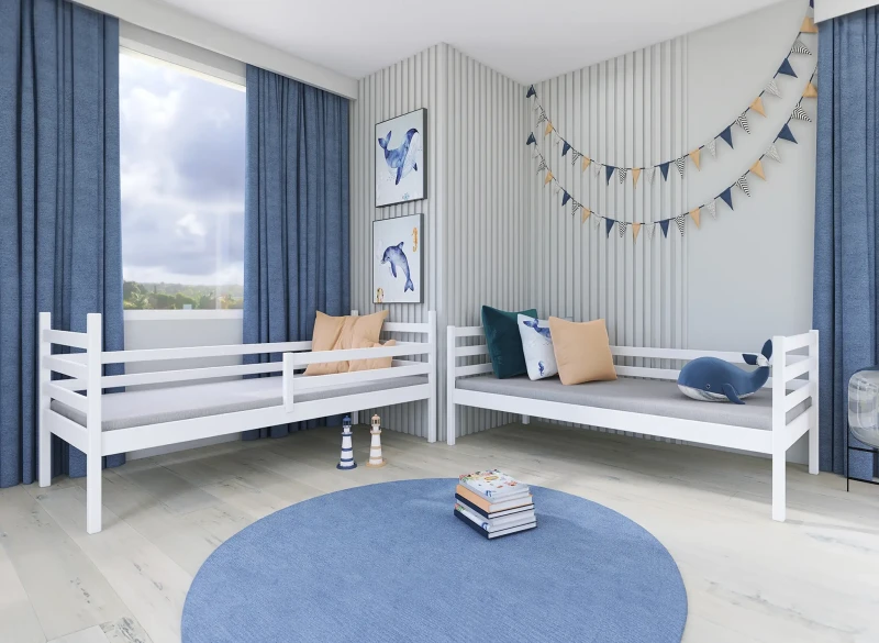Pokój dziecięcy w stylu morskim z dwoma białymi łóżkami i niebieskimi dodatkami.
