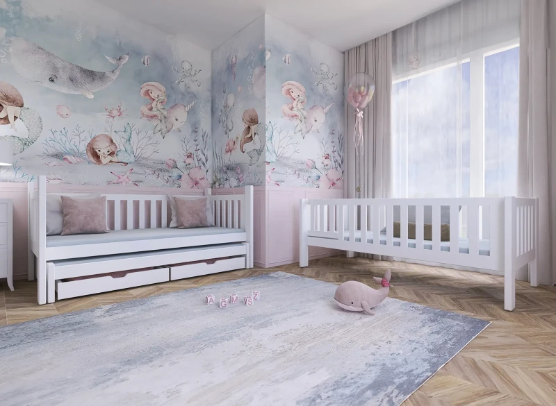Białe łóżeczko dziecięce z szufladami i standardowe łóżeczko w pokoju z tapetą podwodną.