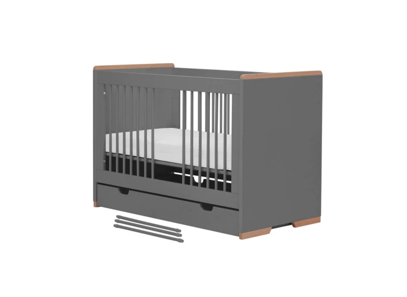 Szare łóżeczko niemowlęce z szufladami i drewnianymi elementami, z materacem, na białym tle.