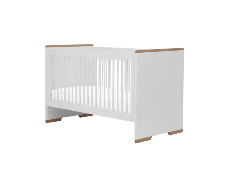 Białe łóżeczko niemowlęce z drewnianymi wstawkami na rogach.