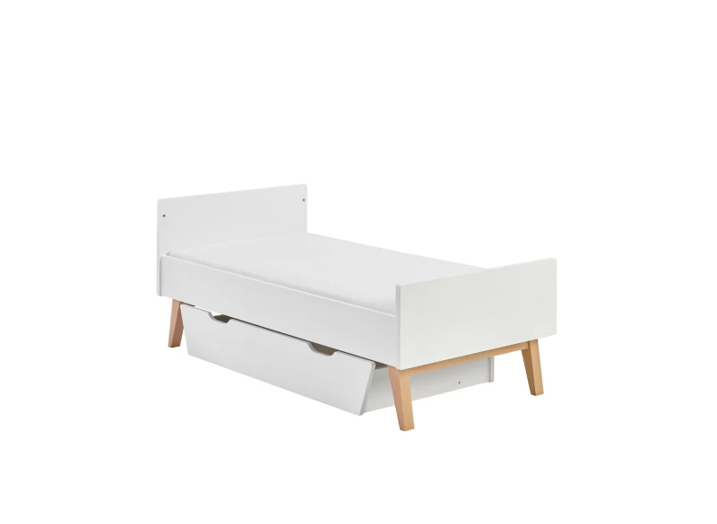 Białe łóżko dziecięce z szufladą na pościel, z drewnianymi nóżkami, na białym tle.