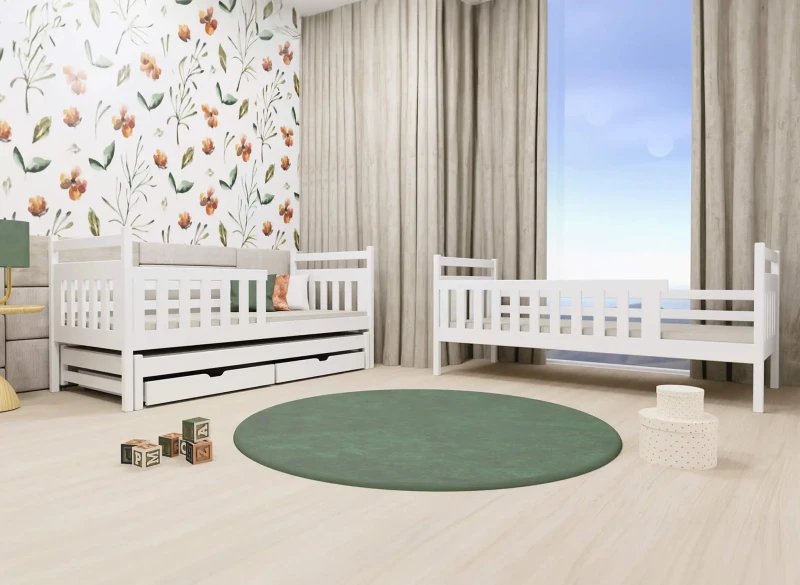 Białe łóżko dziecięce z szufladami i łóżeczko niemowlęce w pokoju z tapetą w kwiaty i zielonym dywanem.