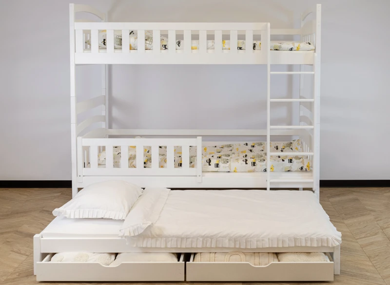Białe łóżko piętrowe trzyosobowe z dodatkowym wysuwanym spaniem i pościelą.