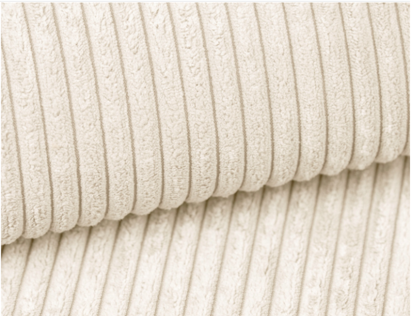 Tekstura jasnobeżowej tkaniny sztruksowej, zbliżenie na materiał obiciowy mebli.