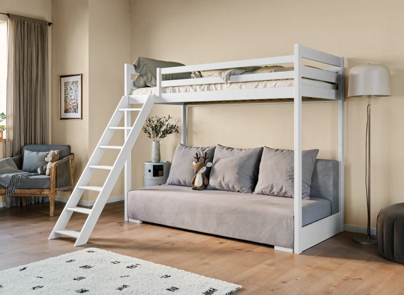 Białe drewniane łóżko piętrowe z drabiną i szarą sofą