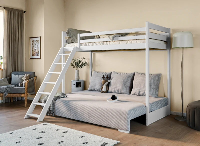 Rozłożona sofa pod białym łóżkiem antresolą w pokoju nastolatka