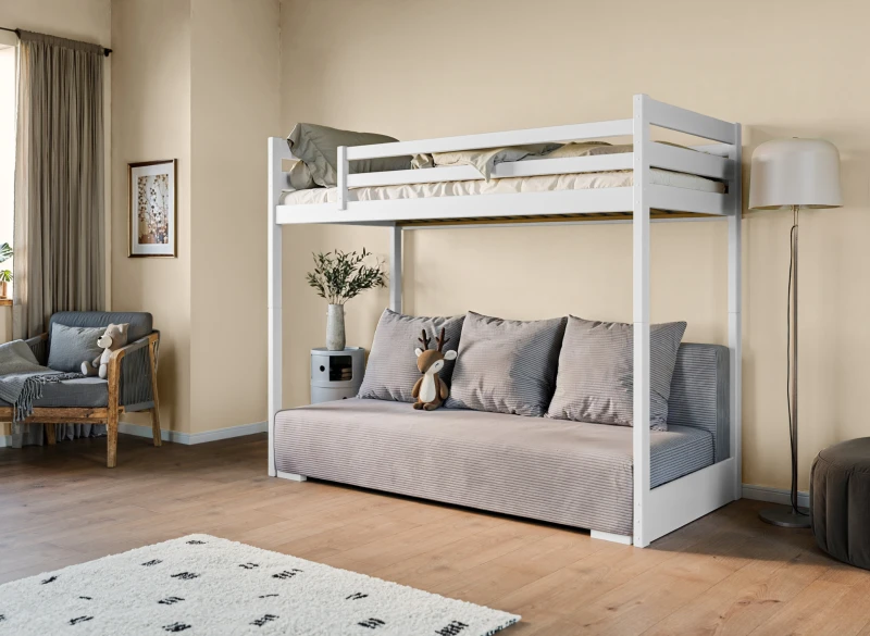 Białe łóżko antresola z drabiną i wygodną szarą kanapą