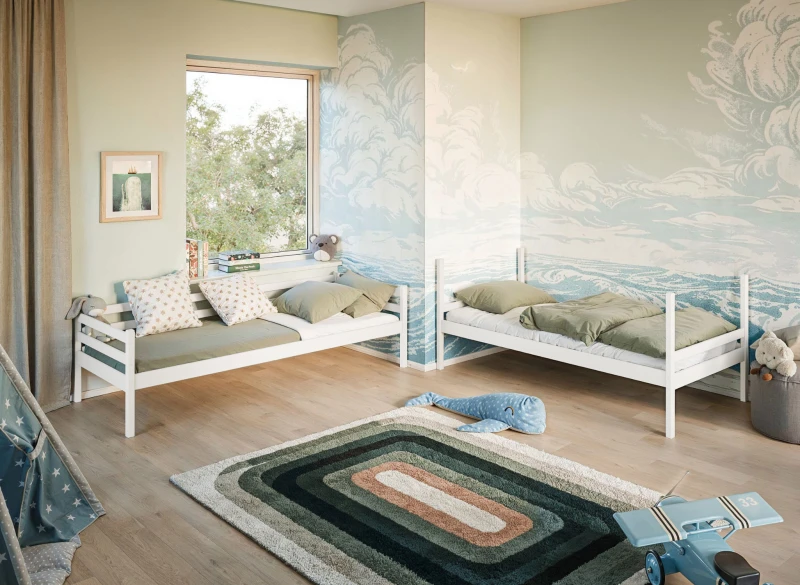 Białe drewniane łóżka dziecięce z barierką, z zieloną pościelą, w aranżacji pokoju z tapetą w fale.
