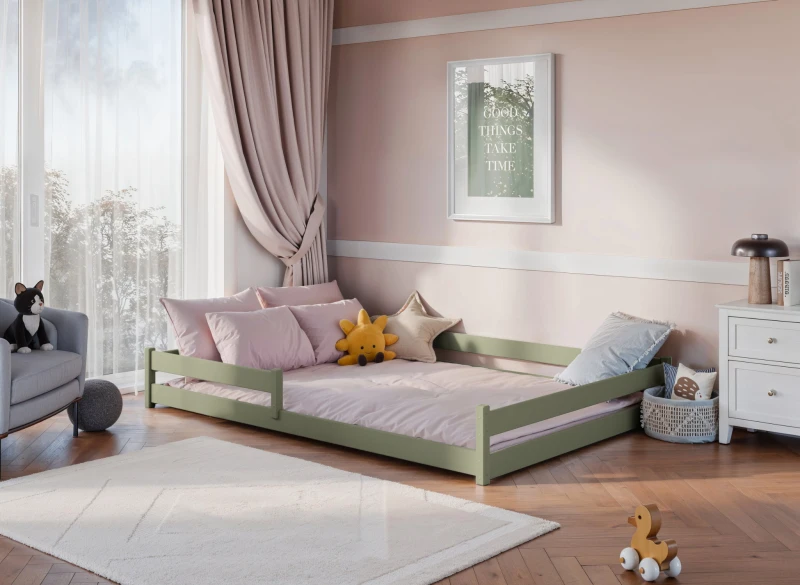 Oliwkowe łóżko dziecięce z barierkami i różową pościelą, w przytulnym pokoju dziecięcym z oknem.