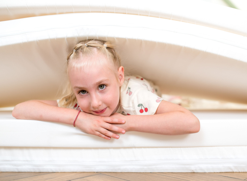 Dziewczynka leżąca na wygodnych materacach.