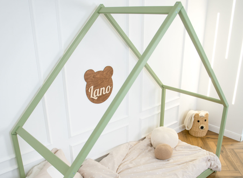 Zielone łóżko dziecięce domek na tle białej ściany z napisem Lano.