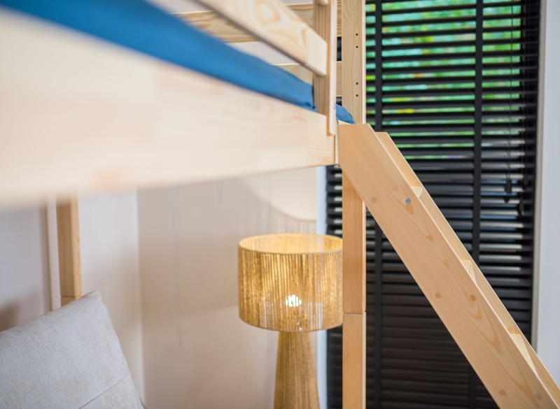 Zbliżenie na schodki i konstrukcję drewnianego łóżka antresoli.