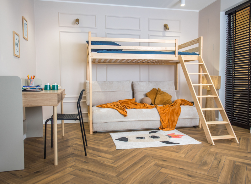 Łóżko antresola z drewna z sofą i dywanem z motywem rakiety
