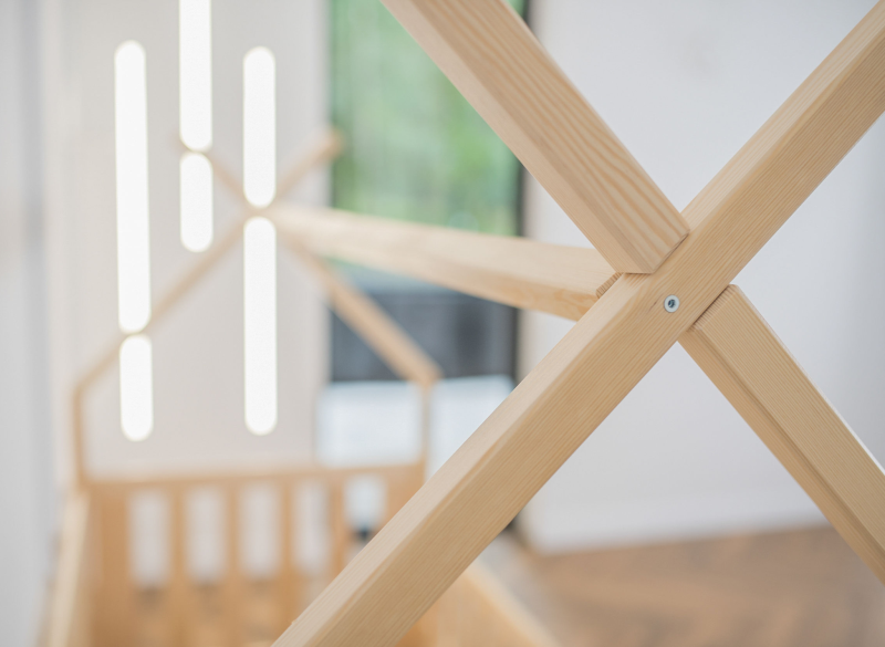 Zbliżenie na precyzyjne łączenie belek w konstrukcji drewnianego łóżka domek.