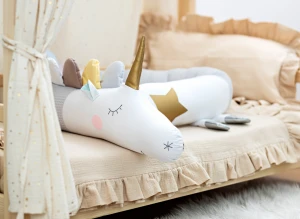 Pluszowy jednorożec ochraniacz do łóżeczka w przytulnym pokoju dziecka.