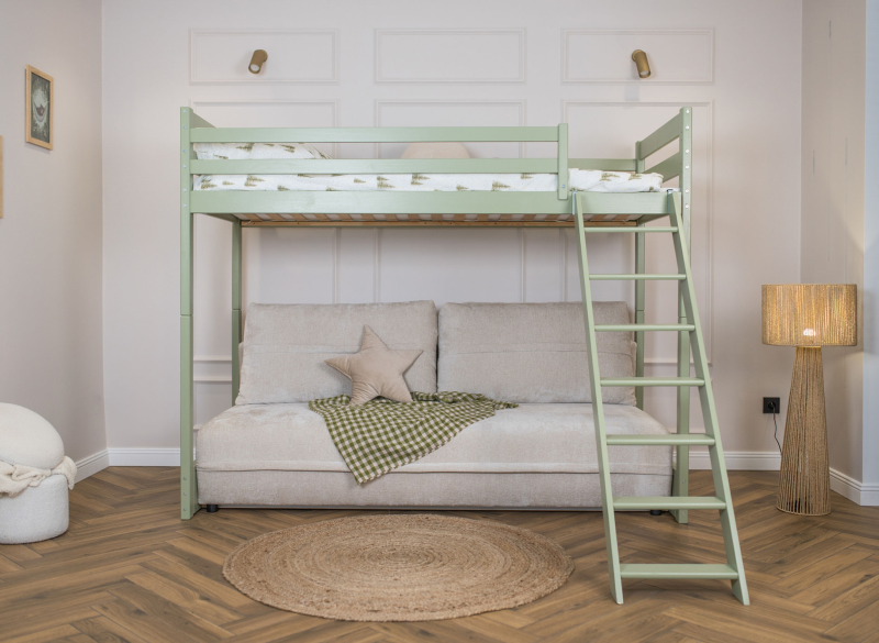 Szałwiowe łóżko na antresoli z sofą i drabinką w pokoju dziecięcym.