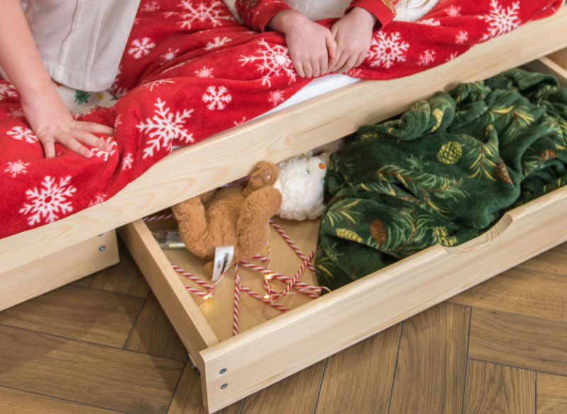 Praktyczna szuflada pod łóżkiem na pościel i zabawki.
