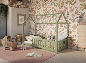 Oliwkowe łóżko domek dla dziecka na tle kwiecistej tapety z sarenkami.