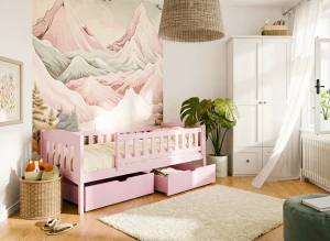 Różowe drewniane łóżko dla dziecka z miejscem do przechowywania i białą szafą.