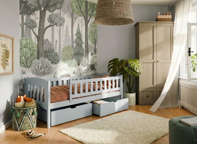Błękitne łóżko dziecięce z szufladami w pokoju z modną leśną tapetą.