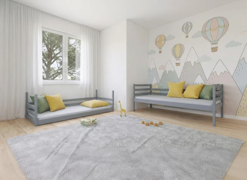 Aranżacja pokoju dla dziecka z dwoma szarymi łóżkami i dekoracyjną ścianą z motywem gór.