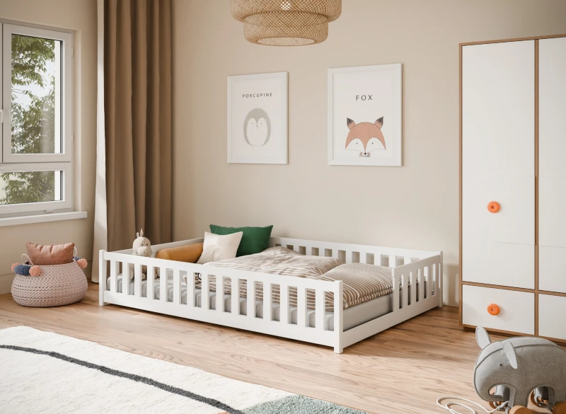 Białe łóżko dziecięce montessori z barierkami w przytulnej aranżacji pokoju.