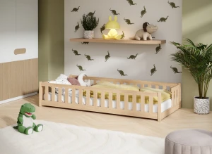 Niskie drewniane łóżko dziecięce z barierkami w pokoju z dinozaurami.