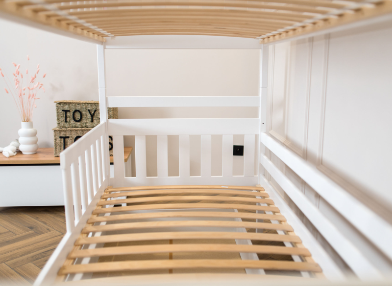 Solidny stelaż białego łóżka piętrowego z drewnianymi listwami, widok z bliska.