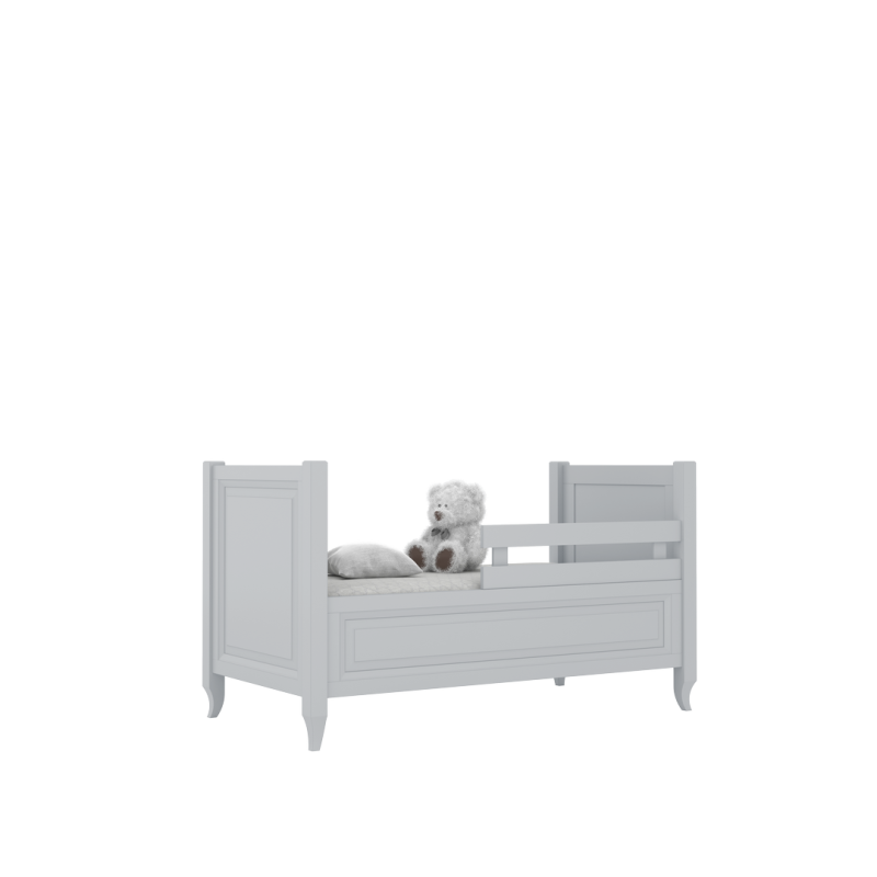 Białe łóżko dziecięce z barierką ochronną, materacem i pluszowym misiem.