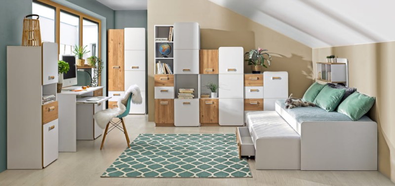 Biało-dębowe meble młodzieżowe z wysuwanym łóżkiem w jasnym pokoju na poddaszu.