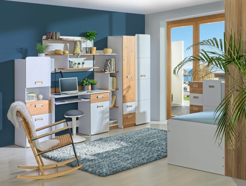 Strefa nauki w pokoju nastolatka: biurko, regał i fotel bujany na tle niebieskiej ściany.