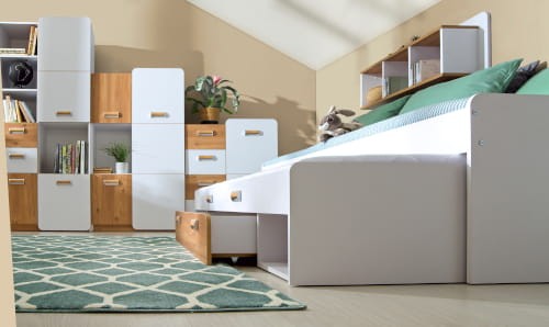 Meble młodzieżowe w kolorze białym i drewna z wysuwanym łóżkiem i szafkami modułowymi.